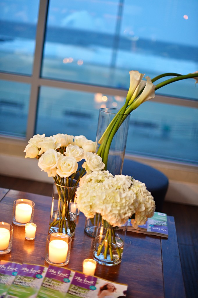 The 2012 Knot/Bump party was decorated by Kate Duffy of Katydid Signature Events and Floral Design.  It featured groupings of white calla lilies, white roses, and white hydrangea all at varying heights with soft white votive candles.  Photo courtesy of John Arcara Photography.